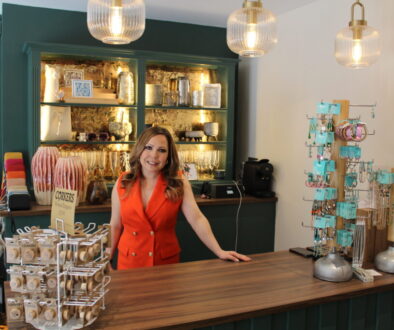 Sammy from Styled Right based in Caterham Valley is pictured standing behind a counter wearing a red waistcoat
