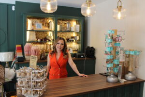 Sammy from Styled Right based in Caterham Valley is pictured standing behind a counter wearing a red waistcoat